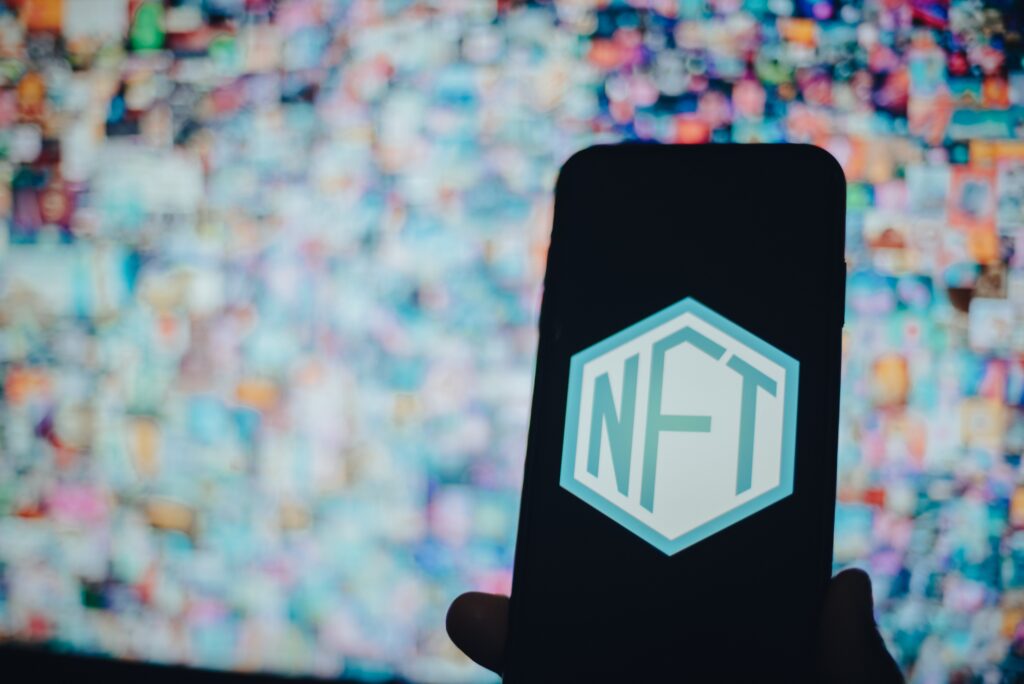 Step Into Financial Freedom with NFTs: Use Your Digital Assets to Make Bigger, Better Promises and Achieve Your Dreams a person holding a mobile phone with an nft with a 2022 11 03 09 35 26 utc